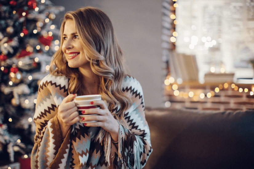 girl cozy in living room with christmas tree